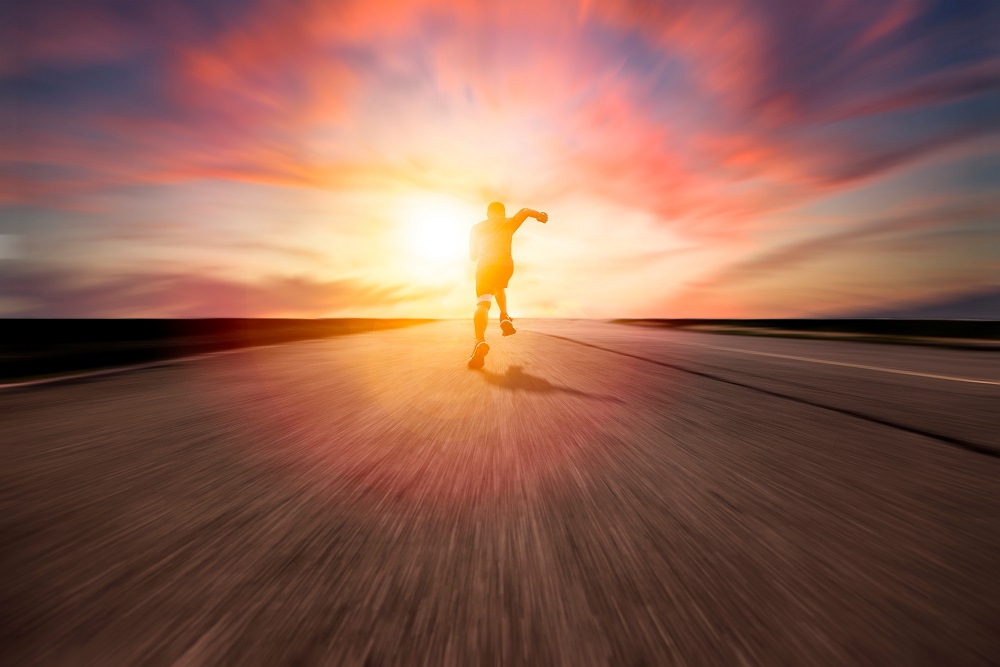 rear view man running and sprinting on the road with blur background