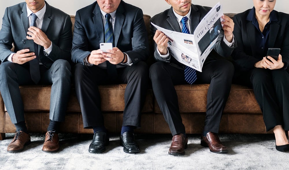 Business people busy with mobile and reading newspaper