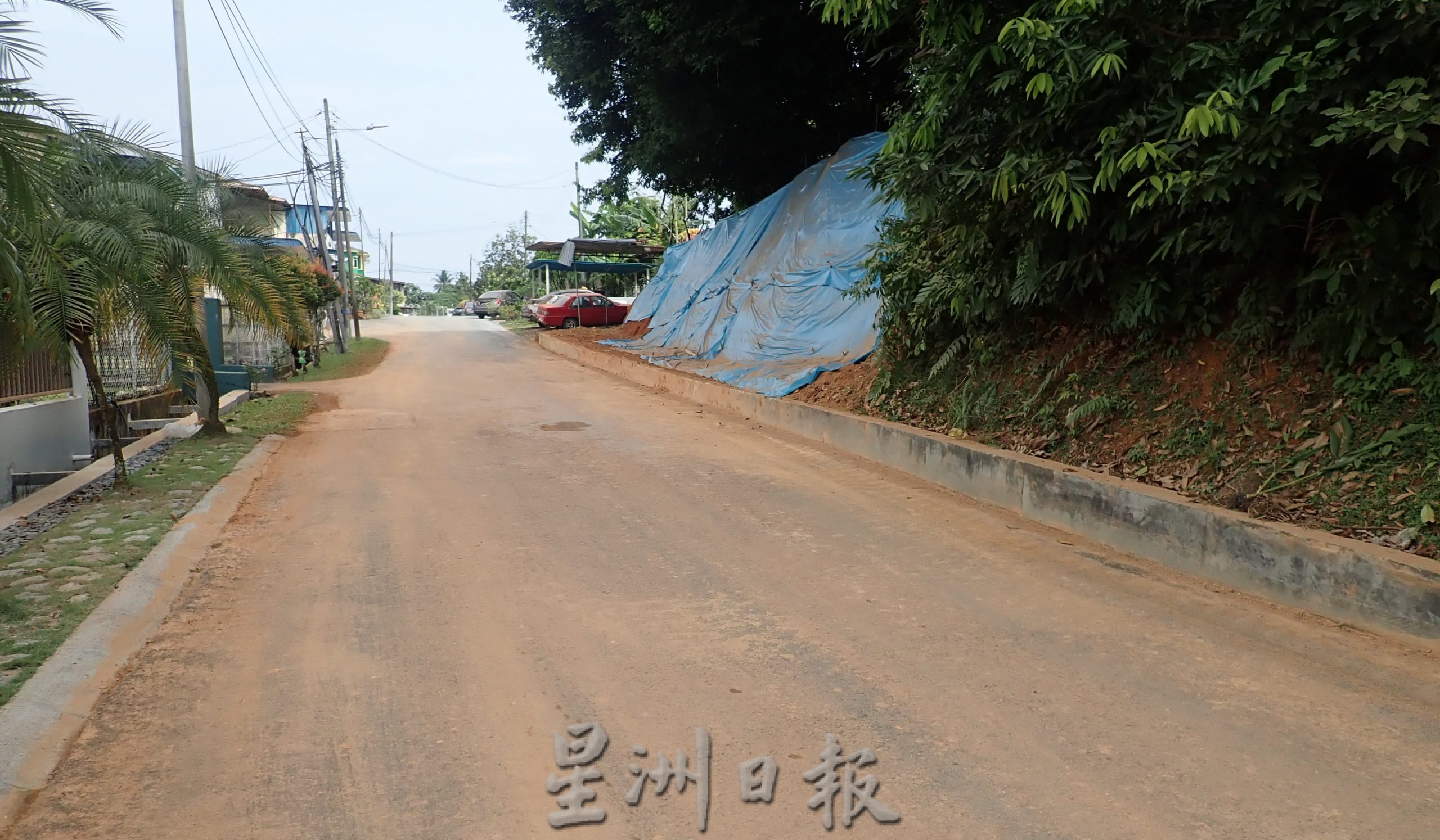 以吹葉機吹路面紅泥  引“紅塵飛揚”氣煞居民