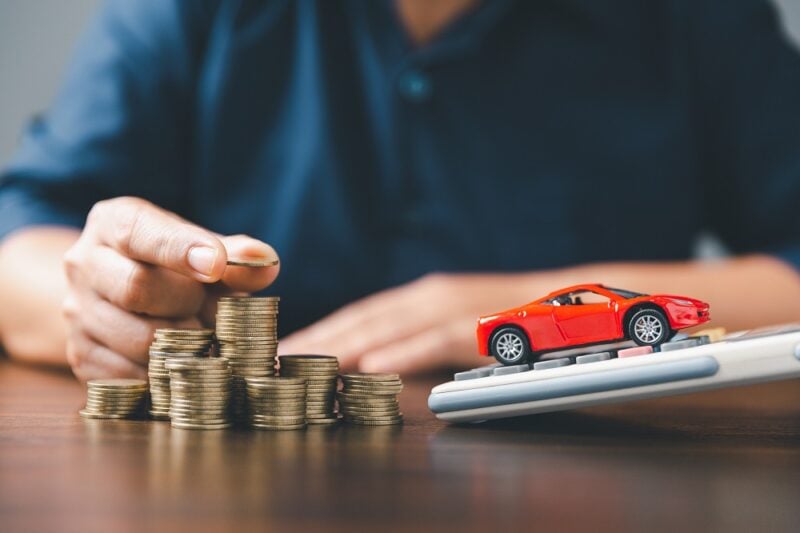 Concept of car insurance business, saving buy - sale with tax and loan for new car. Car toy vehicle with stack coin money on background. Planning to manage transportation finance costs. loan for car