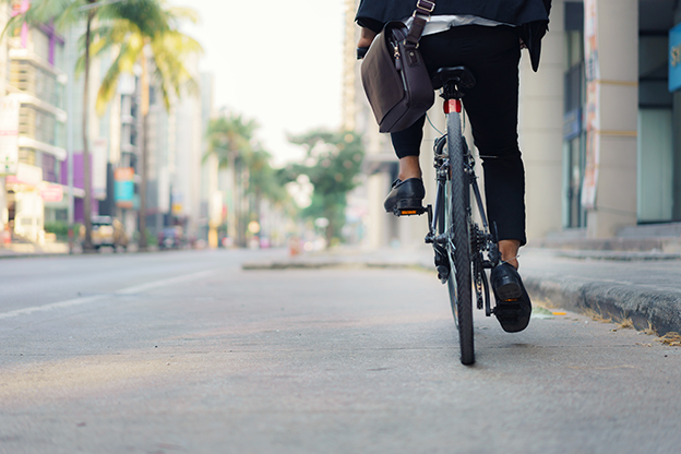 Close up of foot businessman is riding a bicycle on the city str