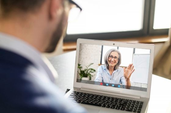 Over the shoulder photo of man sitting at laptop