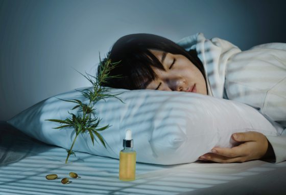 Asian girl sleeping in evening bedroom with cbd oil, capsules and a cannabis branch. Melatonin production, concept of combat sleep disorders