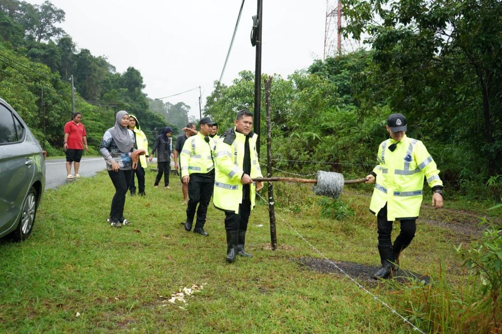 东：警民同心，登州总警长及警员协助村民装置铁丝篱笆，防止村民饲养的水牛在水灾灾区游荡。