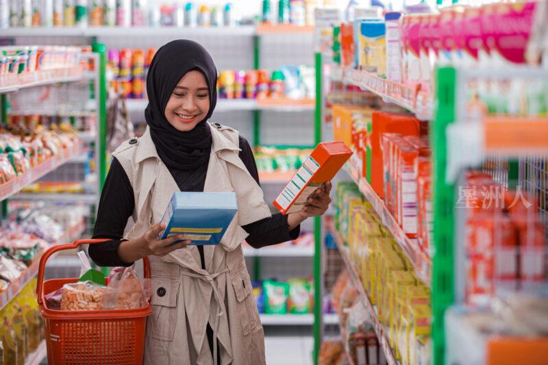 Pretty,asian,muslim,woman,comparing,between,two,products,in,supermarket