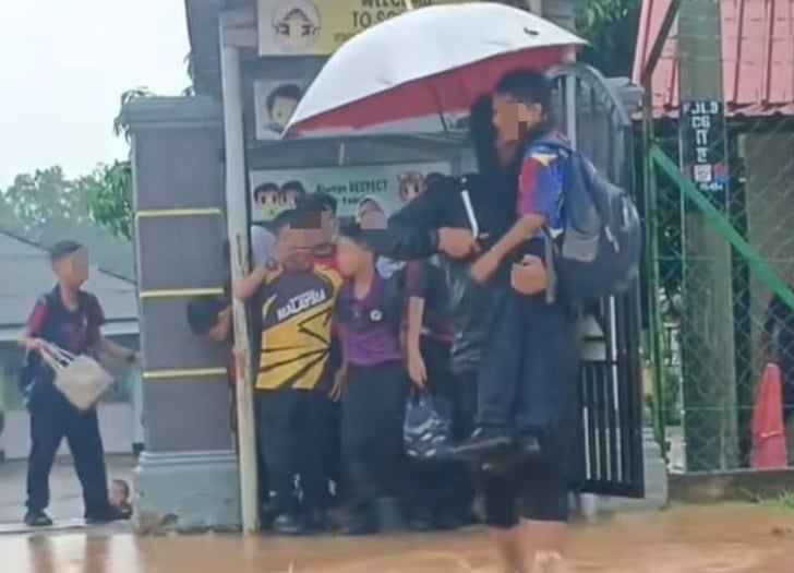 雨天校门积水学生受困 保安抱起学生涉水而过获赞赏