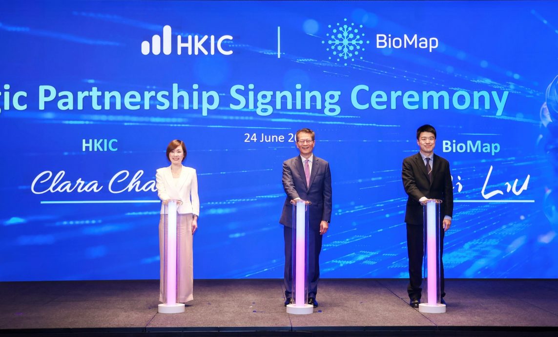 Clara Chan, CEO of HKIC (left), and Wei Liu, CEO of BioMap (right) signed the strategic partnership agreement, witnessed by Paul Chan, Financial Secretary of the Hong Kong SAR Government (centre).