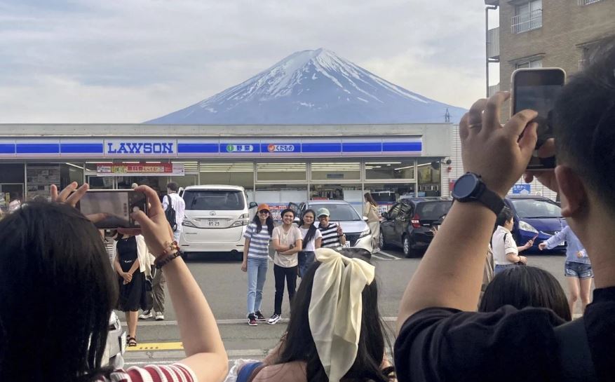 游客冒险挤到桥上拍富士山 日本拟建金属围栏