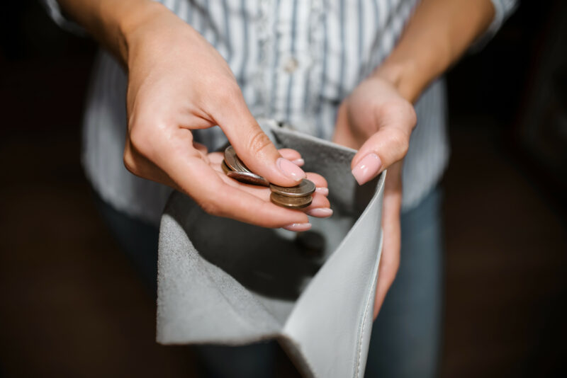 Woman Counts Money, A Close Up Of A Purse With Ruble Coins. The Concept Of Bankruptcy, Income Decline, Job Loss. Selective Focus, Dark Background