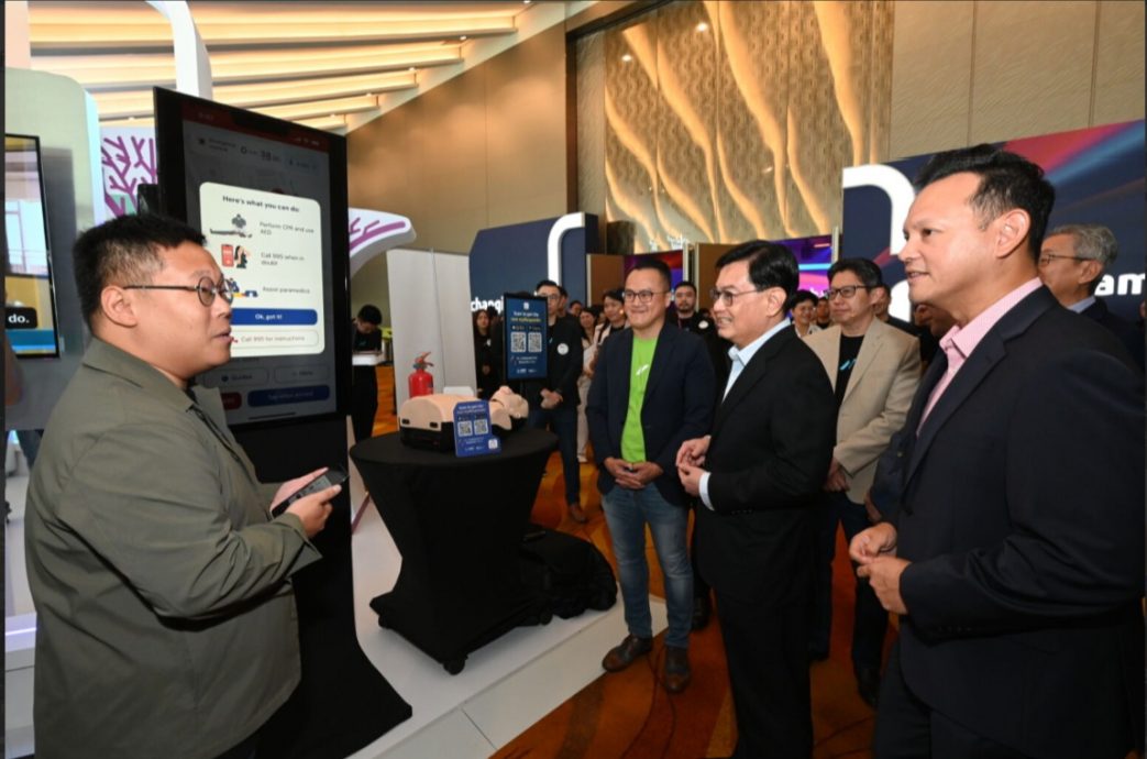 Sam Liew, Chief Executive, Gov+, NCS and Ng Kuo Pin, Chief Executive Officer, NCS, accompanying Deputy Prime Minister Heng Swee Keat and Senior Minister of State for the Ministry of Manpower, Zaqy Mohamad, on a demonstration of how AI is innovating emergency services to improve outcomes.