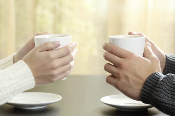 Hands Of Couple With Coffee Cups