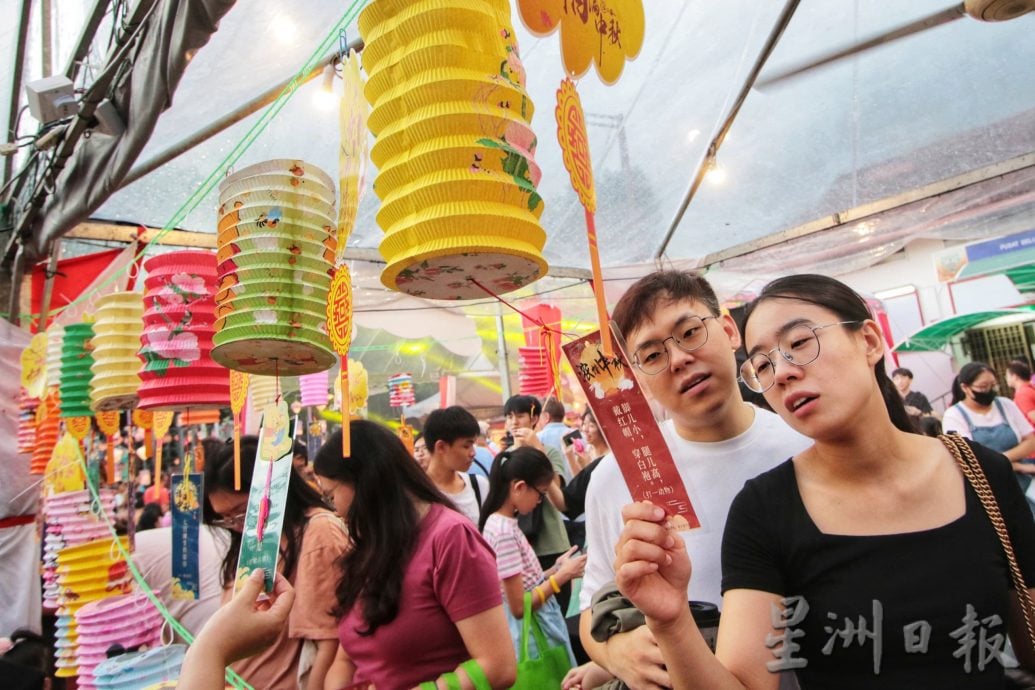 民众撑伞赴会兴致不减 丹绒雨夜庆中秋