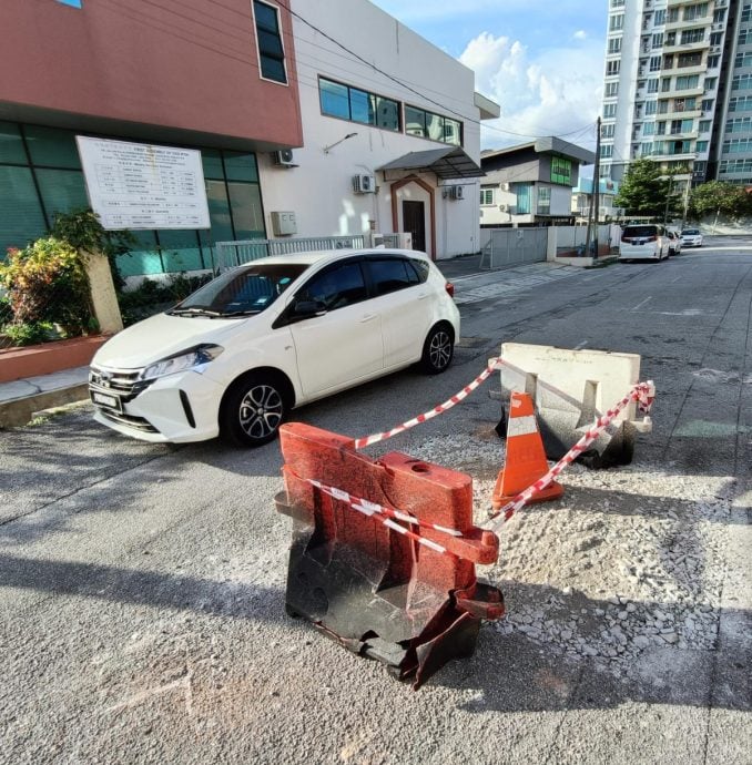 轿车行驶途中突卡轮 路面突下陷现坑洞！