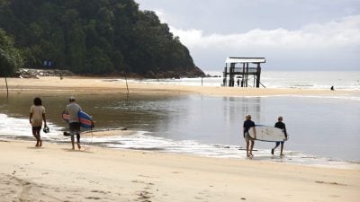 游客无惧雨季迎风逐浪   遮拉丁海滩成冲浪天堂