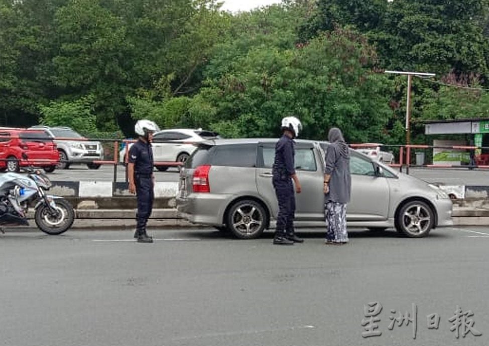 供星洲网:巡警协助妇女启动汽车引擎