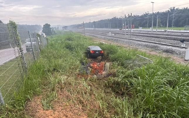 豪车雨中失控，轿车撞火车轨篱笆坠草丛