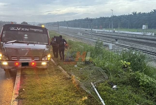 豪车雨中失控，轿车撞火车轨篱笆坠草丛