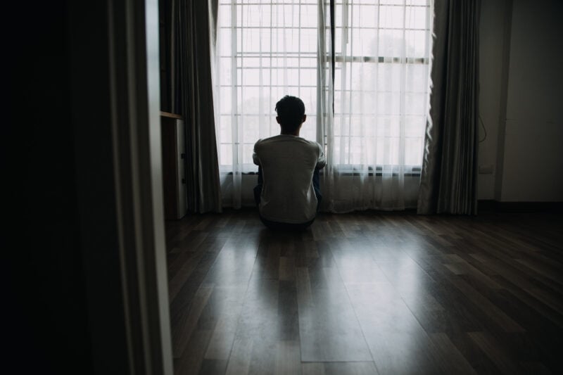 Alone Man Silhouette Staring At The Window Closed With Curtains