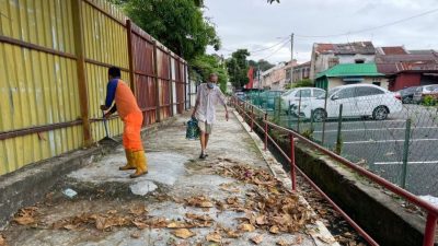 清理走道树叶扫入沟   市民恐沟塞引发水灾