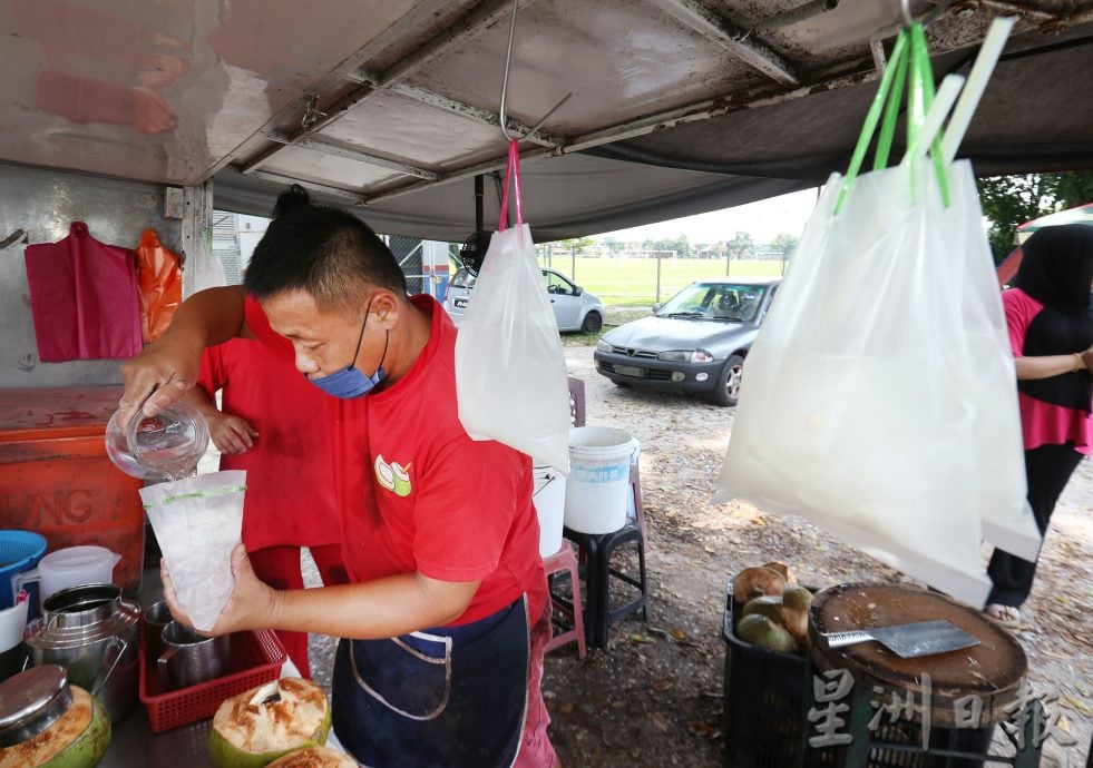 天气火热外出撑伞多喝水 椰水大卖消暑解渴  