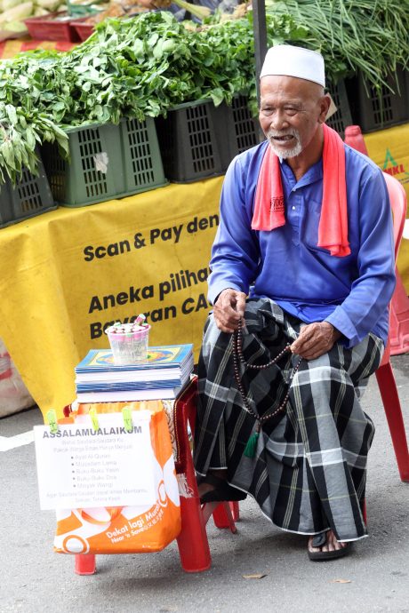 大都会//斋戒月市集转向电子支付 卖艺人失明人士在市集募捐不忘出示账户二维码 